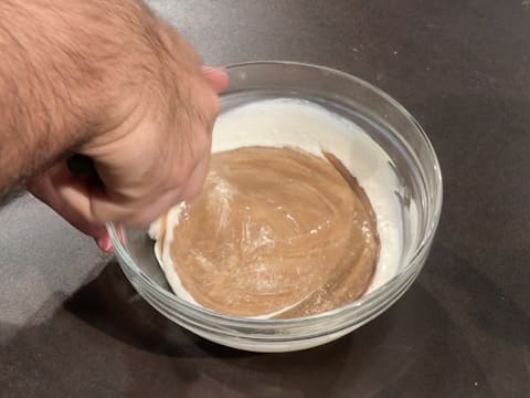 Incorporation de la crème liquide dans la crème au chocolat blanc et au praliné noix de pécan dans le saladier en verre