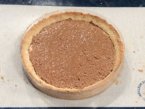 Obtention du fond de tarte cuit recouvert de croustillant noix de pécan sur le tapis de cuisson en silicone