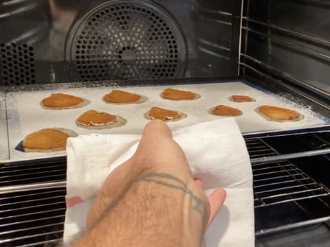 Les tranches de poires saupoudrées de sucre glace et posées sur le tapis de cuisson sur une plaque à pâtisserie, sont cuites et retirées du four