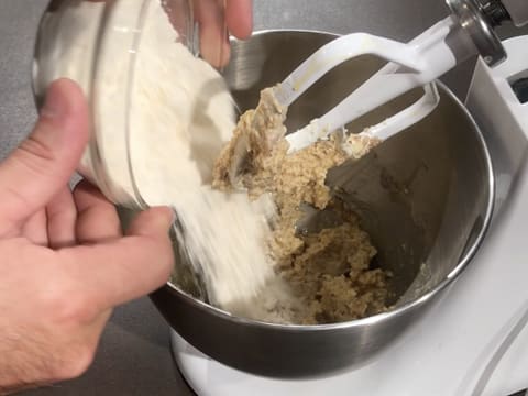 Ajout de la farine sur la pâte dans la cuve du batteur muni de l'accessoire feuille