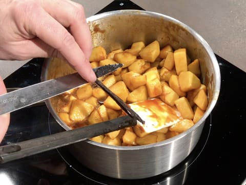 Ajout des grains d'une gousse de vanille à l'aide d'un couteau, dans la casserole contenant les morceaux de pommes caramélisés