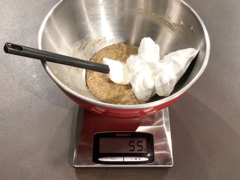 Un peu de meringue est ajoutée sur la pâte dans le cul de poule qui est posé sur une balance de cuisine électronique