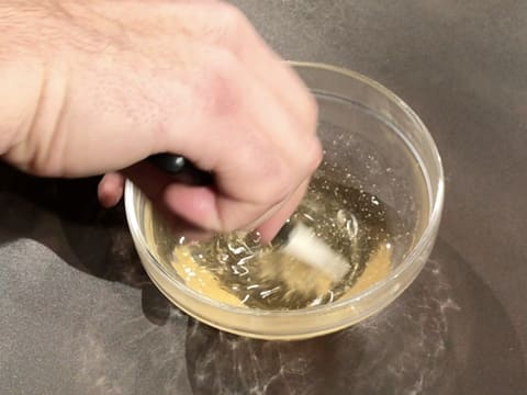 Le nappage miroir neutre fondu est mélangé avec la spatule maryse dans le bol