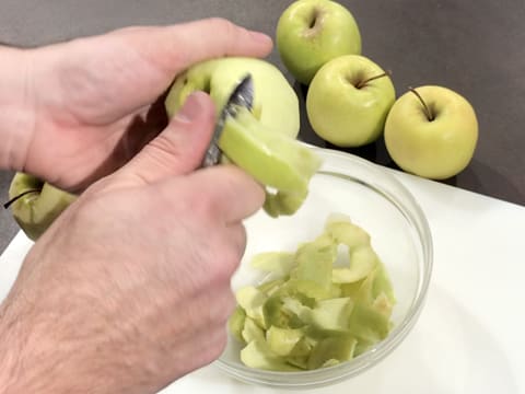 Les pommes Golden sont en train d'être pelés à l'aide d'un éplucheur