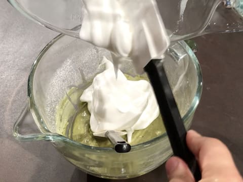 La meringue est versée sur préparation à l'amande et au thé matcha dans la cuve du batteur