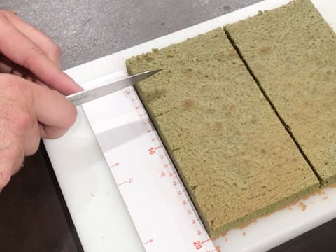 Mesure et marquage de la moitié inférieure du biscuit thé matcha à l'aide de la pointe d'un couteau et d'une règle graduée à tous les 4 cm