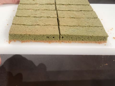 Vue du côté du biscuit thé matcha coupé en dix rectangles sur la planche à découper