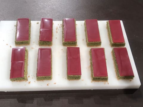 Obtention de dix rectangles de biscuit thé matcha recouverts des plaquettes de chocolat inspiration framboise