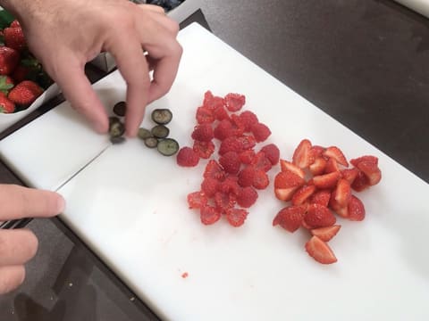 Les fruits rouges sont coupés avec un couteau sur la planche à découper