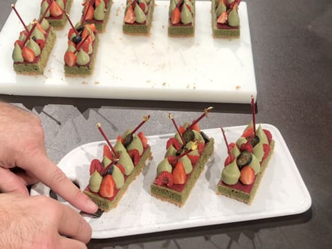 Obtention des tartelettes aux fruits rouges et thé matcha décorées et placées sur le plat de présentation