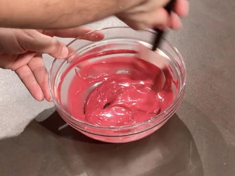 Mélange du chocolat inspiration framboise dans le bol en verre, à l'aide de la spatule maryse