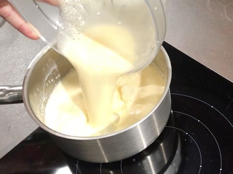 Le mélange crème liquide et chocolat blanc fondu est versé dans la casserole qui est placée sur la plaque de cuisson