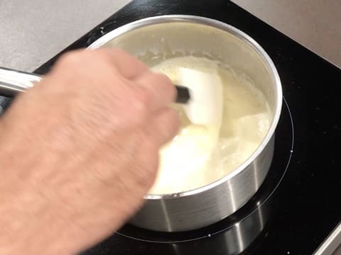 La crème au chocolat blanc est cuite à la nappe à l'aide de la spatule maryse dans une casserole