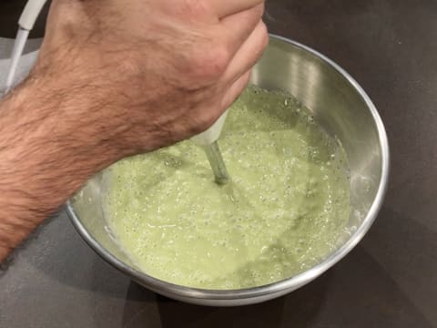 La crème au chocolat blanc et au thé matcha est mixée à l'aide d'un mixeur plongeant dans le cul de poule qui est posé sur le plan de travail