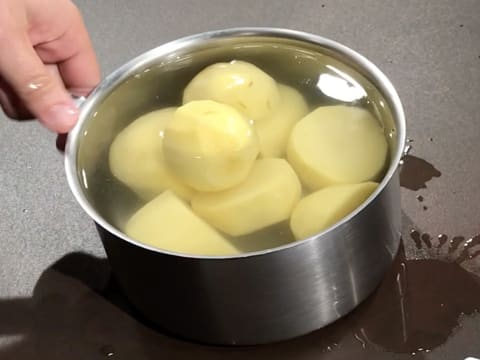 Les pommes de terre sont placées dans une casserole remplie d'eau et posée sur le plan de travail