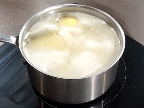 Les pommes de terre sont en train de cuire dans la casserole placée sur la plaque de cuisson