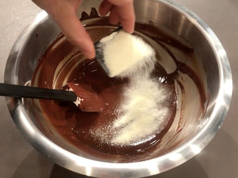 Sprinkle Mycryo cocoa butter over the surface of the melted dark chocolate