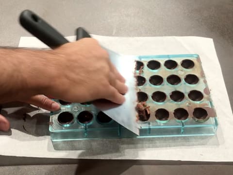 Scrape the surface of the chocolate mould with a spatula