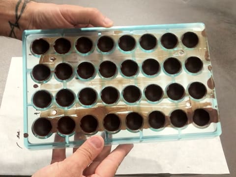 The chocolate shells are in the cavities of the chocolate half sphere mould