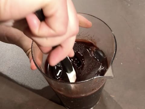 Stir the chocolate icing with a rubber spatula