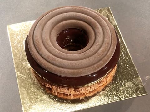 The Easter entremets is placed on a golden square cake board