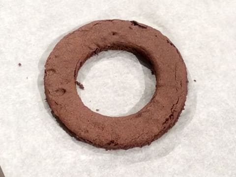 Chocolate biscuit disc on a sheet of greaseproof paper