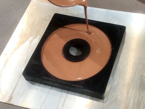 The spiral silicone mould is filled with chocolate crémeux