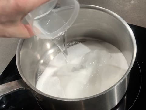 Pour water and castor sugar into a saucepan and place on the stove