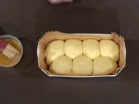 The dough balls have risen inside the wooden tray