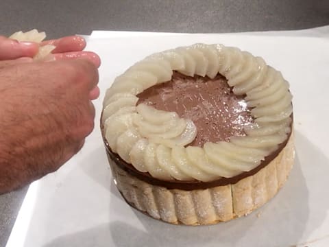 The poached pear slices are arranged into a swirl over the chocolate charlotte