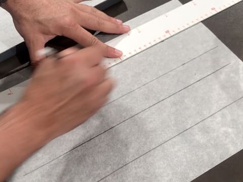 Draw two strips with a pencil and graduated ruler on a sheet of greaseproof paper