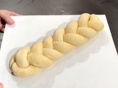 The plaited brioche is centred on a baking sheet