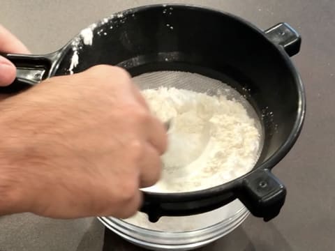 The flour and potato starch are sifted over a bowl