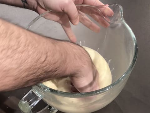 La pâte à beignets est dégazée en tapant dessus avec le poing