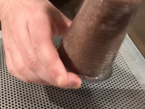 Le biscuit éponge cacao est démoulé sur une plaque à pâtisserie