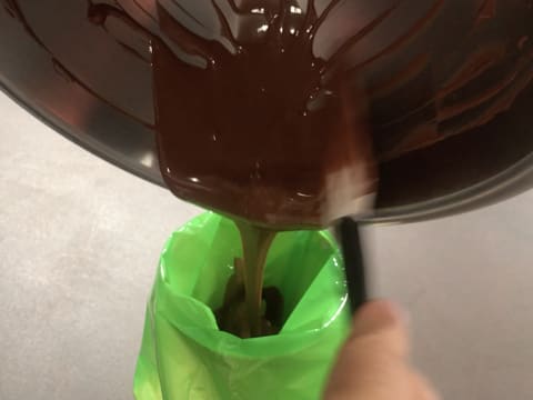 Le chocolat au lait fondu et tempéré est versé dans une poche à douille