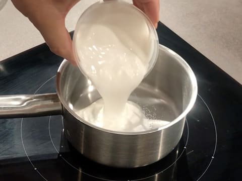 La crème de coco est versée dans la casserole qui contient le sucre inverti et le sorbitol