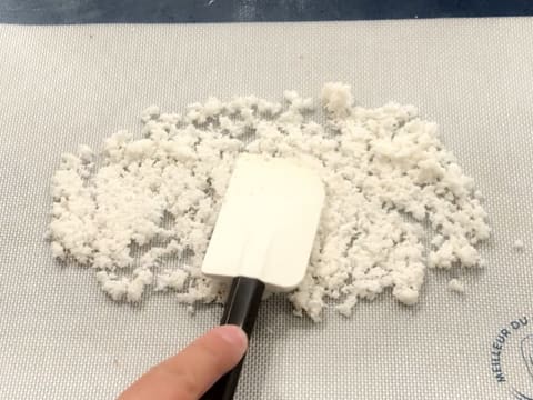 La pâte à la noix de coco est étalée sur un tapis de cuisson en silicone