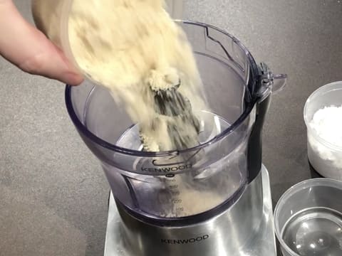 Ajout de la poudre d'amandes dans la cuve du mixeur
