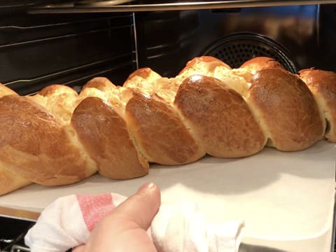 Le pain brioché tressé est cuit et sort du four