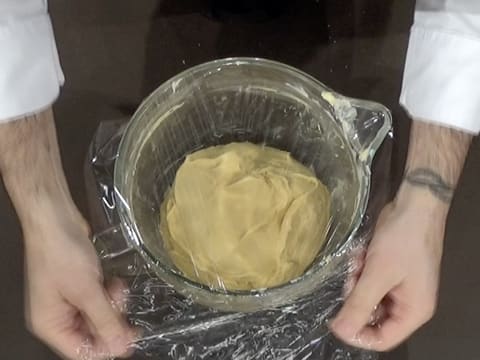 La cuve contenant la pâte à brioche est filmée avec une feuille de papier film