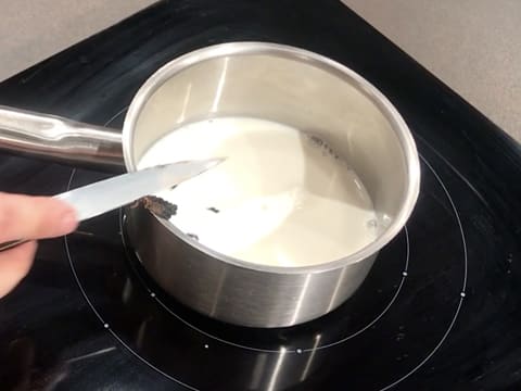 Les grains de vanille sont placés dans la casserole qui contient le lait et qui est placée sur la plaque de cuisson