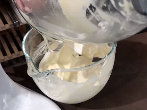 Le pré-mélange de beurre fondu avec la préparation à base des poudres, oeufs battus et blancs en neige, est versé sur la préparation dans la cuve du batteur