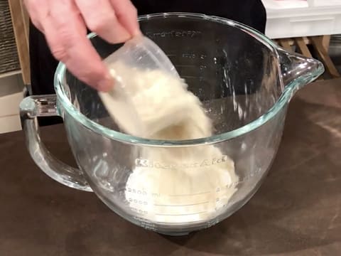 Ajout de la poudre d'amandes sur le sucre glace dans la cuve du batteur