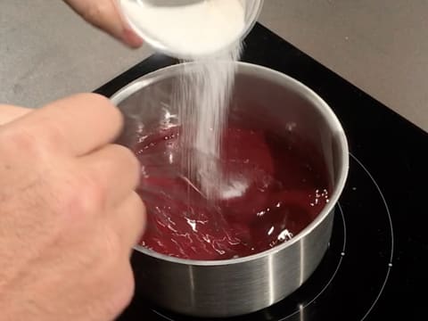 Ajout du mélange pectine NH nappage et sucre en poudre sur la purée de framboise, dans la casserole