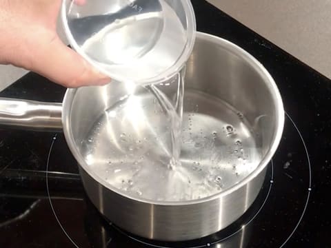 L'eau et le sirop de glucose sont versés dans une casserole