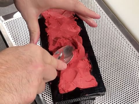 Le sorbet framboise est étalé dans le moule à bûche silicone