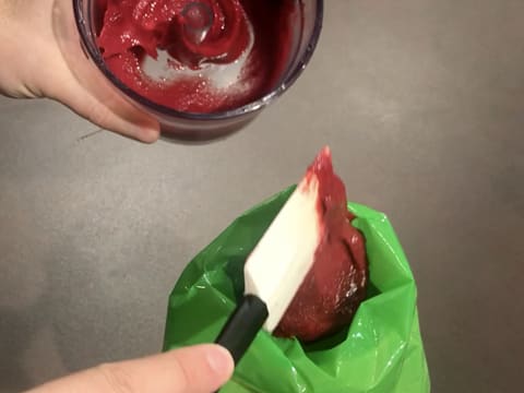 Le confit de framboise est versé dans une poche à douille