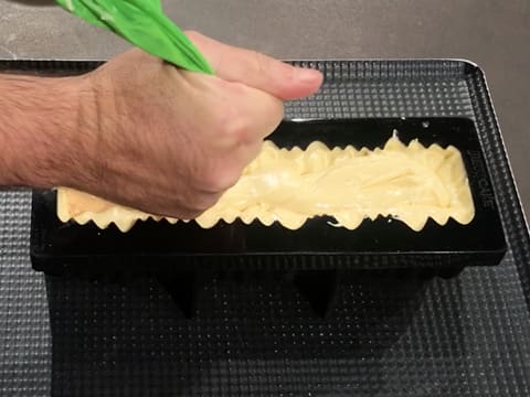 La mousse Inspiration passion est pochée dans le moule à bûche silicone sur l'insert