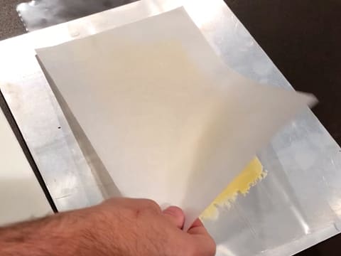 Une feuille de papier sulfurisé est placée sur les bandes de chocolat